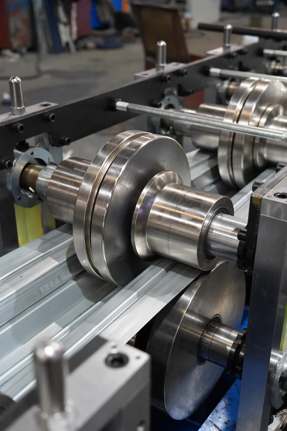 Close view of polished roll tooling installed on shafts in a roll forming line