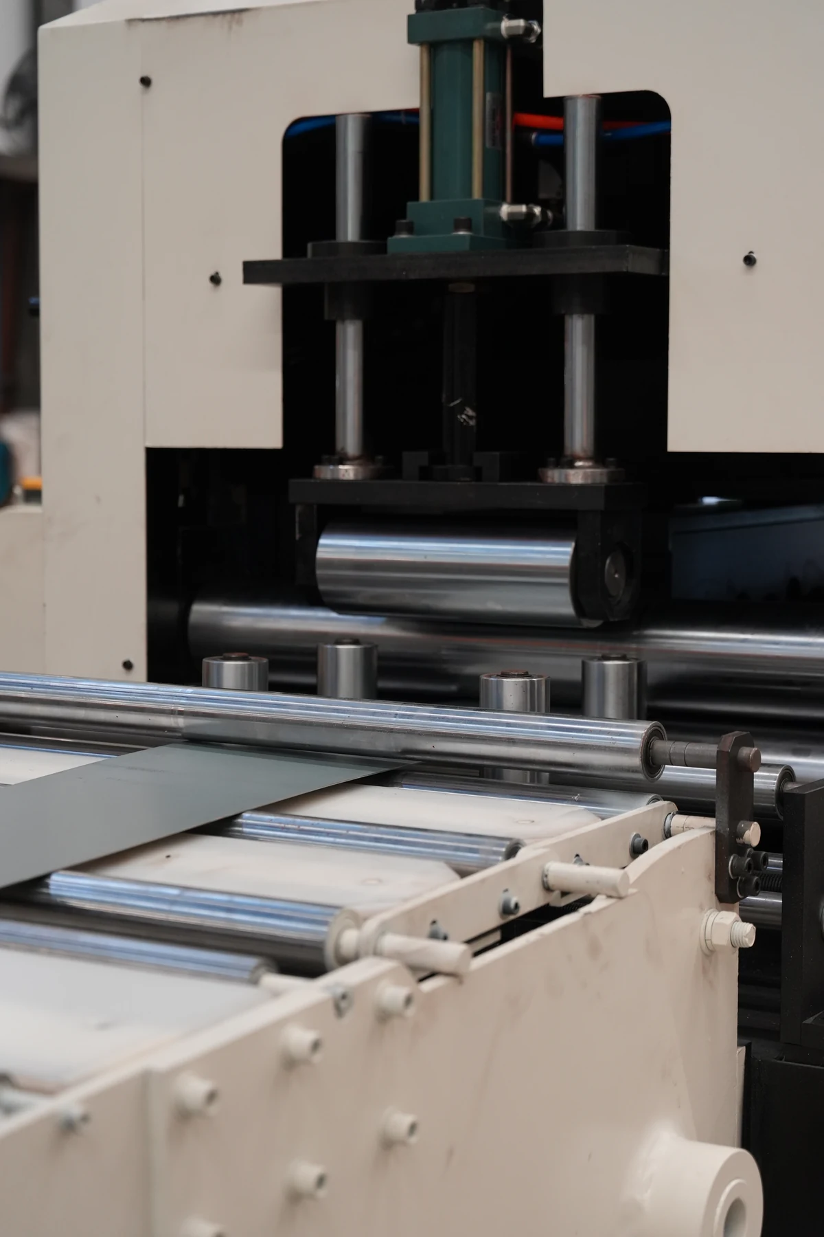 Metal strip approaching rollers at a roll-forming station during a workshop visit