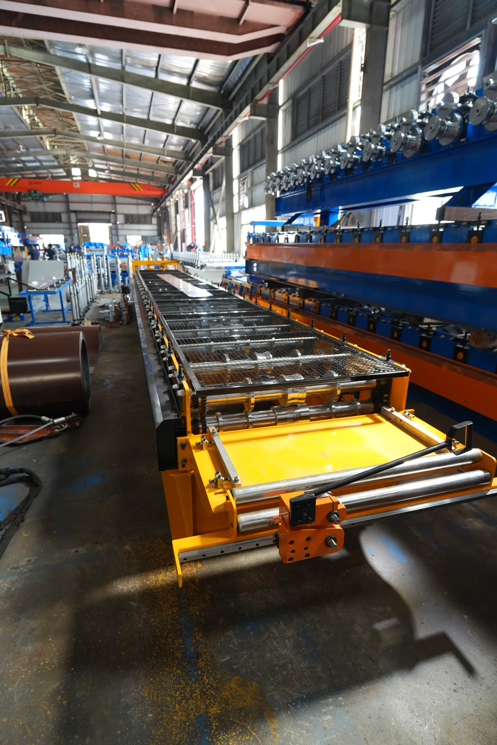 Fixed roll-forming line with entry rollers on a factory floor