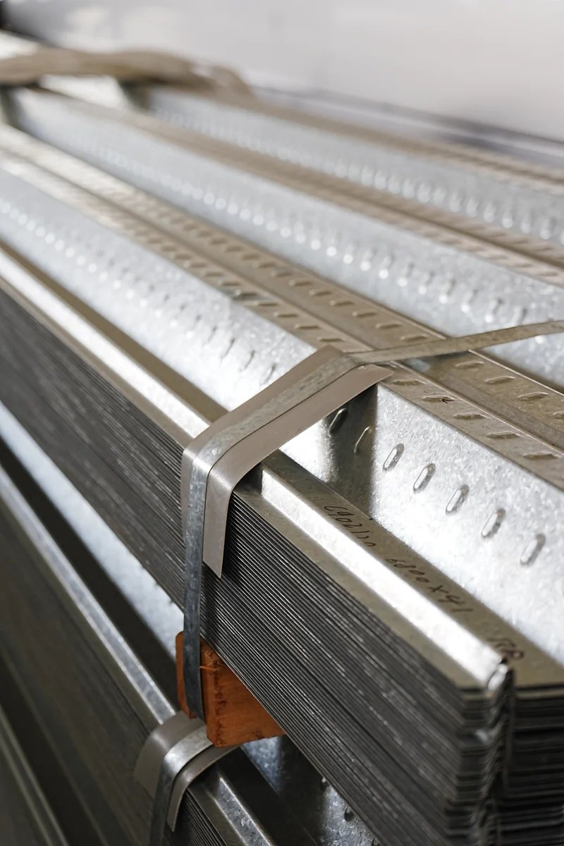 Stack of punched metal channels photographed during a Xiamen factory visit